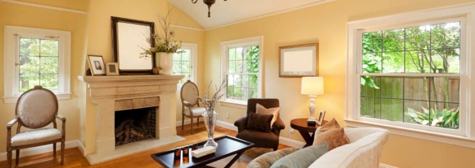 A bright, tidy living room with a fireplace and sunlit windows